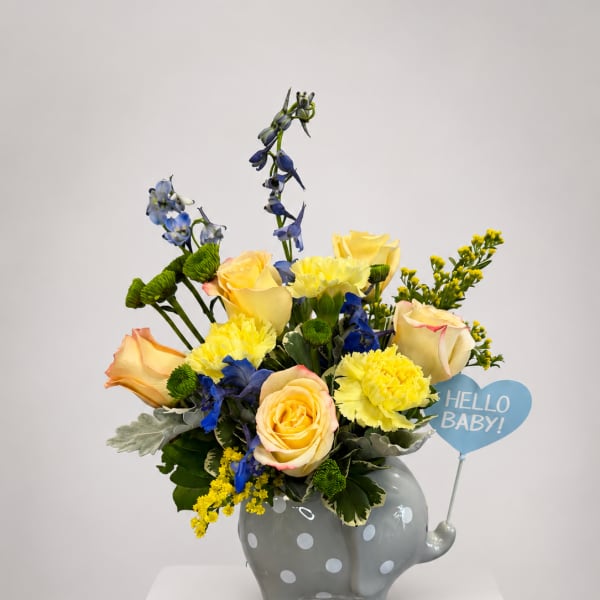 Yellow roses and blue flowers in a gray polka-dot elephant vase with a "Hello Baby!" sign