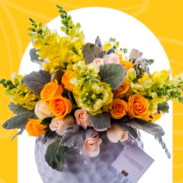 Yellow and orange rose bouquet in a lavender vase with a gift card