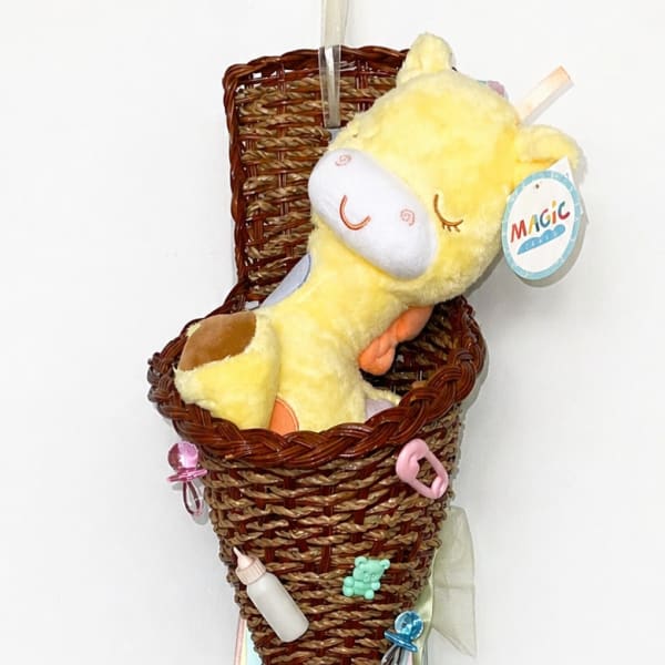 Wicker cone with a plush yellow giraffe and pastel ribbons