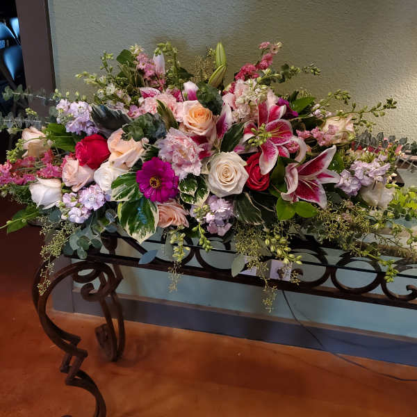 Large mixed floral arrangement with pink lilies and roses on a table