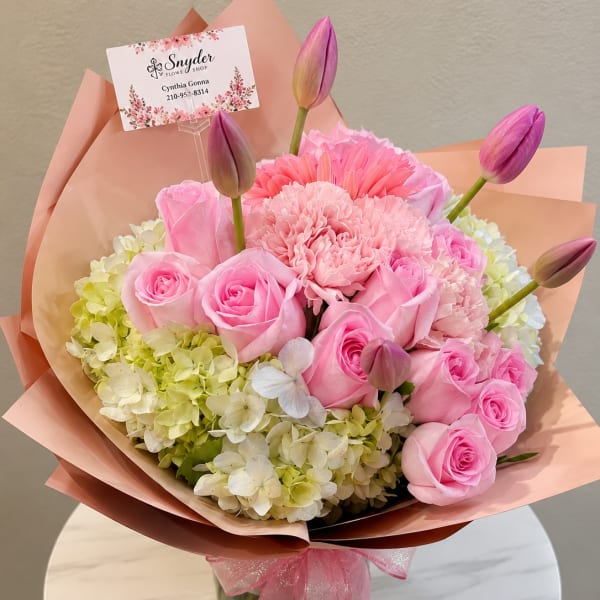 Pink roses and carnations with tulip buds in peach wrapping
