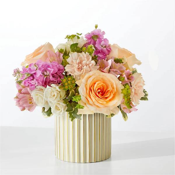 Pastel bouquet of roses and carnations in a striped vase