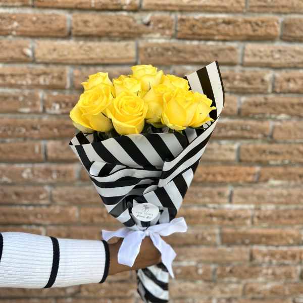 Bouquet of yellow roses wrapped in black-and-white striped paper
