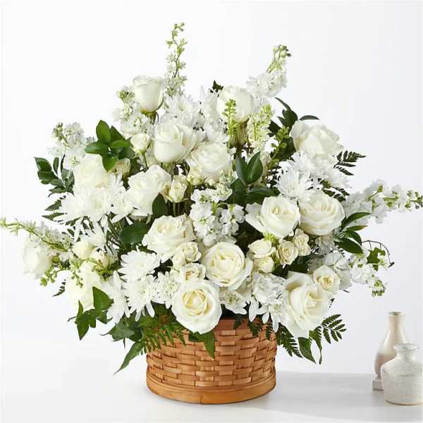 White roses and daisies arranged in a woven basket