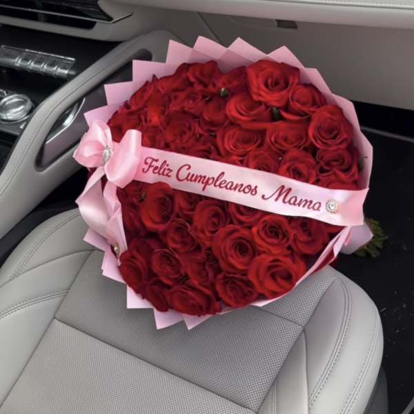Heart-shaped bouquet of red roses with a pink ribbon in a car seat