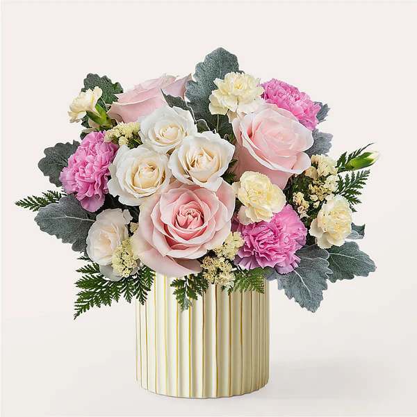 Pink and white rose bouquet in a gold-striped vase