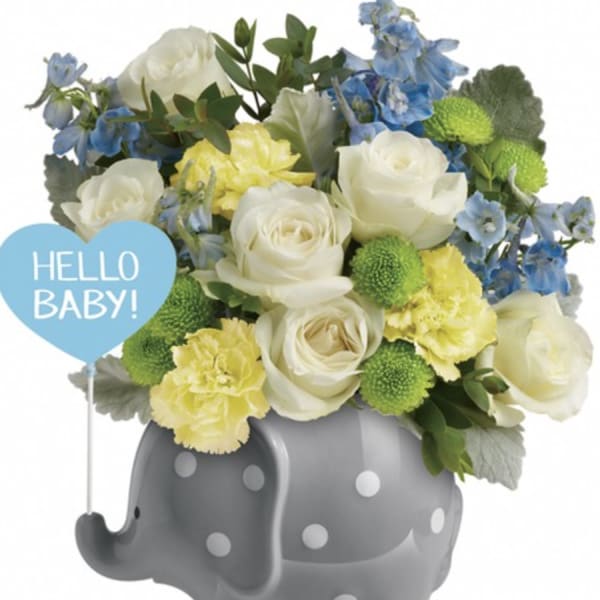 White and blue flowers in a gray polka-dot elephant container with a "Hello Baby!" sign