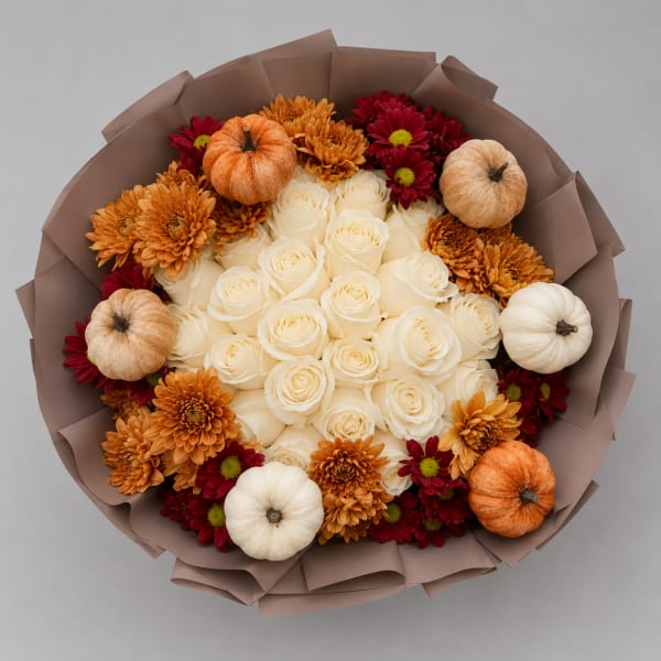Bouquet of white roses with orange and red chrysanthemums and small pumpkins