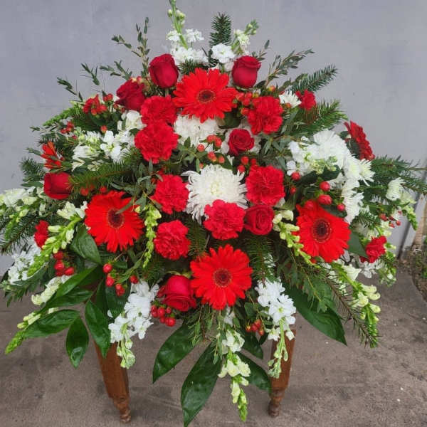 Large red and white floral arrangement with gerbera daisies, roses, and carnations