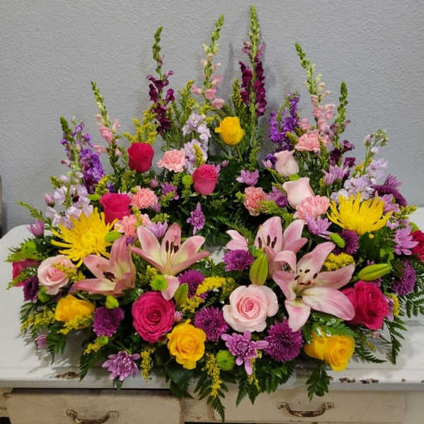 Large colorful floral arrangement with roses, lilies, and snapdragons