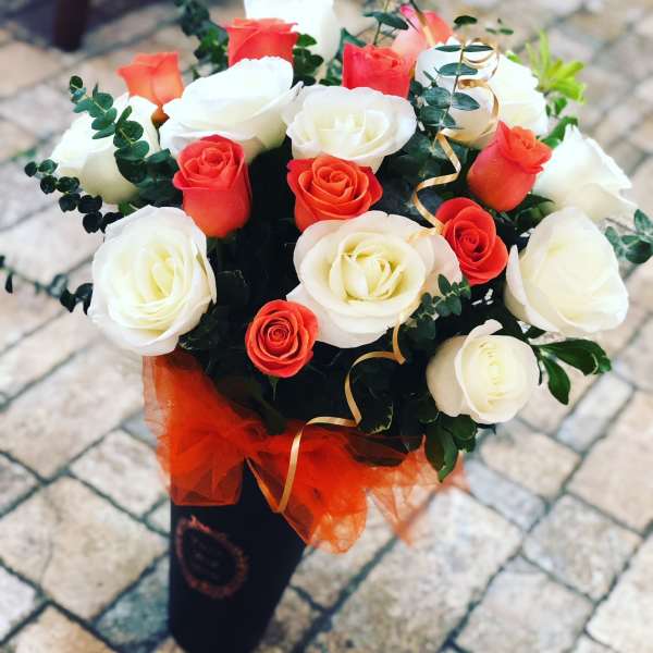 Bouquet of red and white roses with ribbon in a black wrap