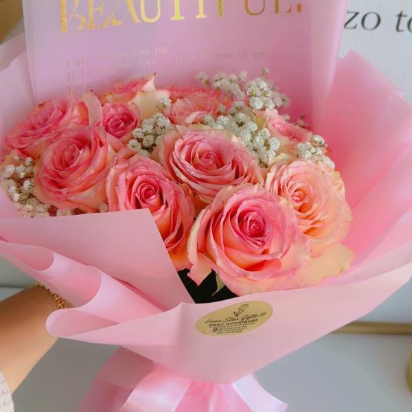 Pink rose bouquet wrapped in translucent paper with a gold "BEAUTIFUL" card