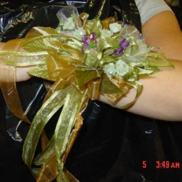 Gold ribbon wrist corsage with small purple and white flowers