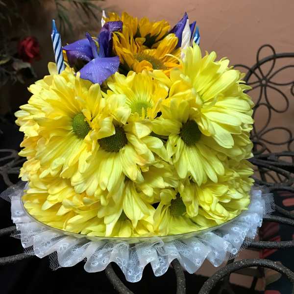 Yellow daisy bouquet with purple accents and striped candles