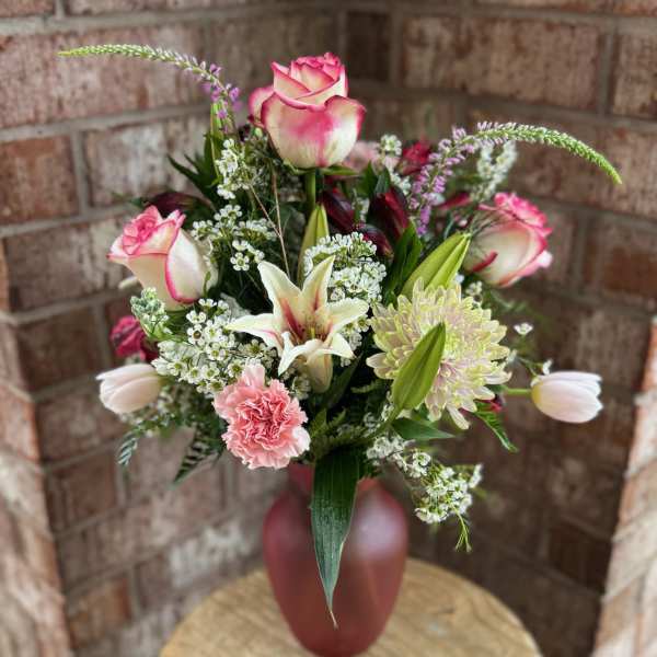 Pink and white bouquet in a red vase