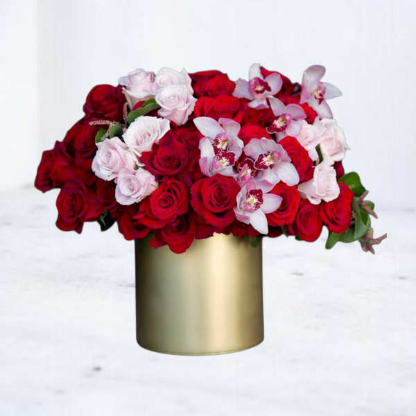 Red and pale pink roses with white orchids in a gold vase