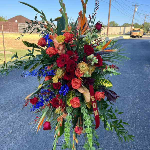 Large standing floral spray with red, orange, and blue flowers