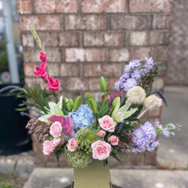 Mixed bouquet in a tall vase with pink, lavender, and white flowers