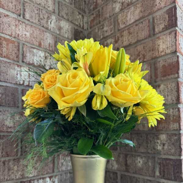 Yellow roses and lilies in a gold vase
