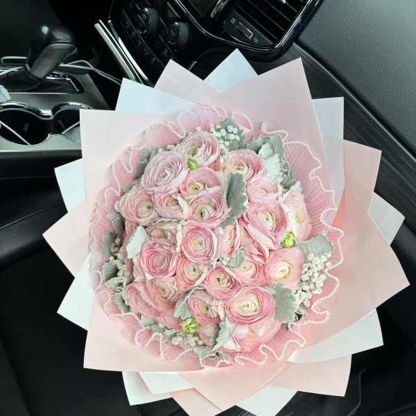 Pink ranunculus bouquet wrapped in pastel paper