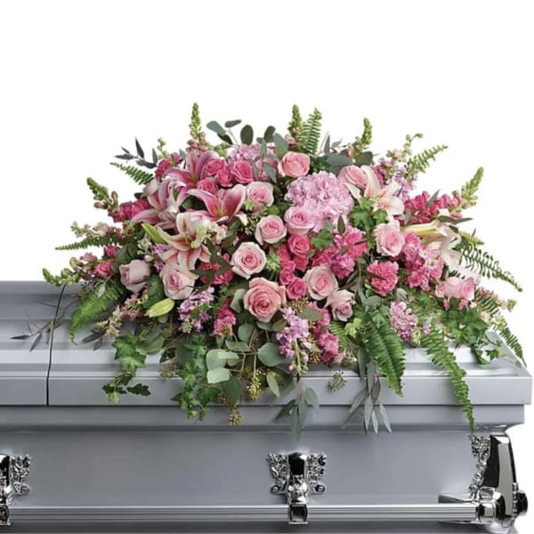 Pink floral casket spray with roses, lilies, and greenery