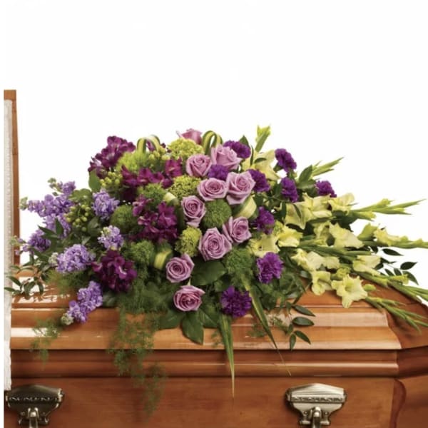 Purple and yellow floral spray on a wooden casket