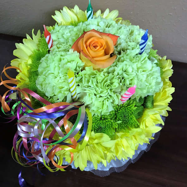 Round bouquet of green carnations and yellow daisies with an orange rose