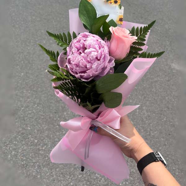 Pink peony and rose bouquet wrapped in pink paper