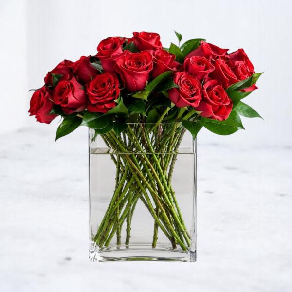Red roses arranged in a clear rectangular glass vase
