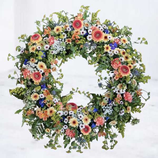 Circular floral wreath with mixed colorful flowers on a white background