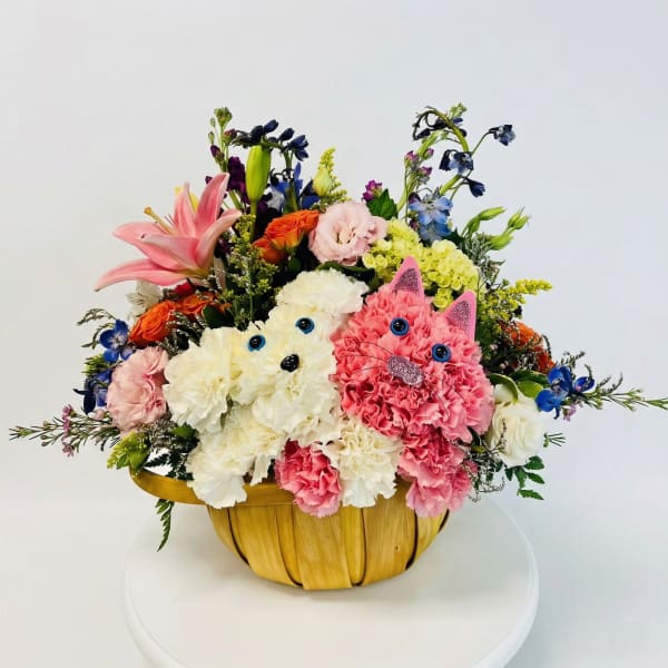 Colorful flower arrangement in a woven basket with two cat faces