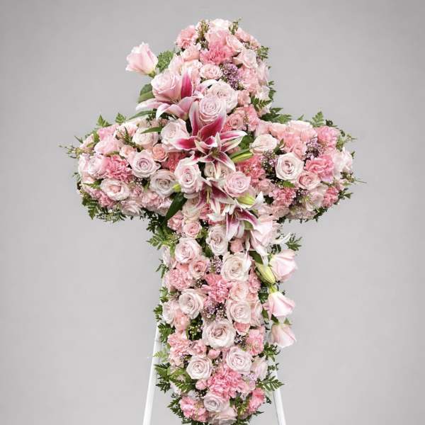Pink floral cross on a white stand