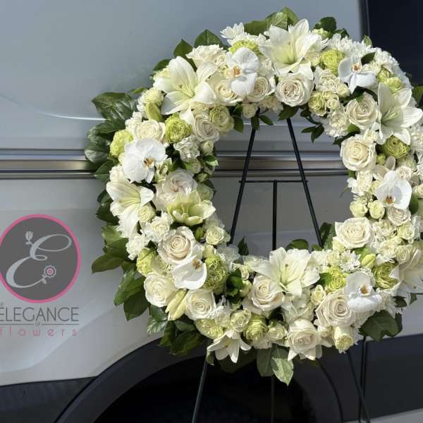 White floral wreath on a black stand