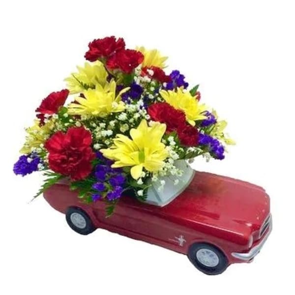 Colorful flower arrangement in a red car-shaped container