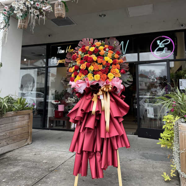 Large standing bouquet of multicolored roses wrapped in bright pink paper