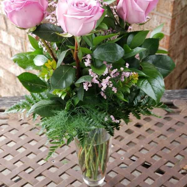 Pink roses arranged in a clear glass vase