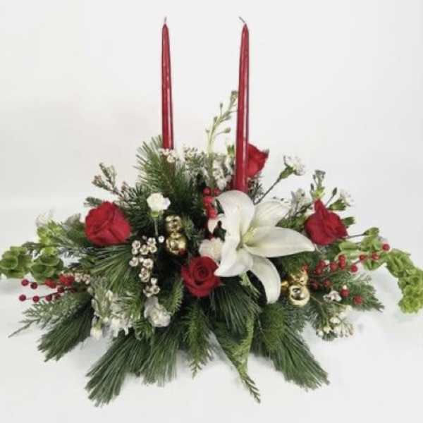 Holiday floral centerpiece with red candles, white lily, and red roses