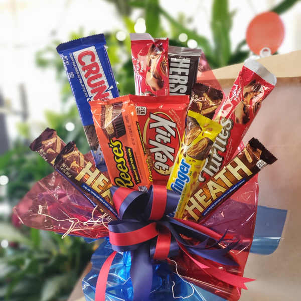 Assorted chocolate candy bars wrapped in colorful cellophane with a ribbon bow