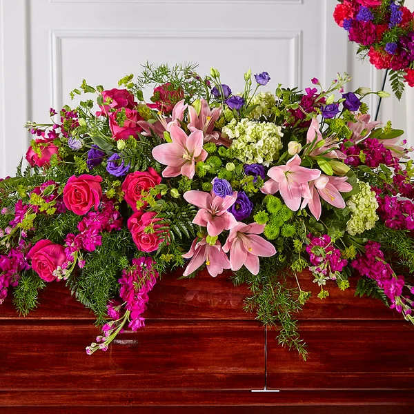 Large pink and purple floral casket spray with lilies and roses