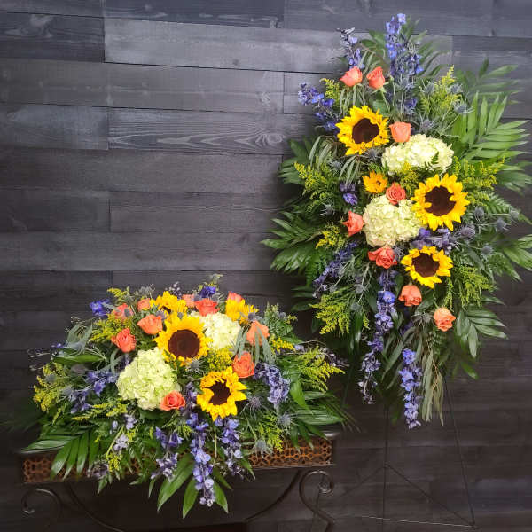 Two large floral sprays with sunflowers, roses, and hydrangeas on stands