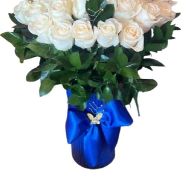Bouquet of white roses with greenery in a blue wrapped vase