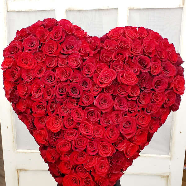 Heart-shaped arrangement of red roses on a stand