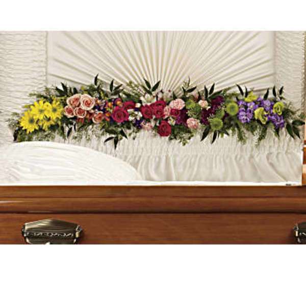 Colorful floral spray arranged across a casket