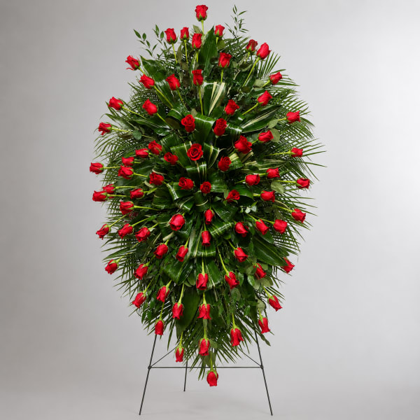 Standing spray of red roses on a metal easel