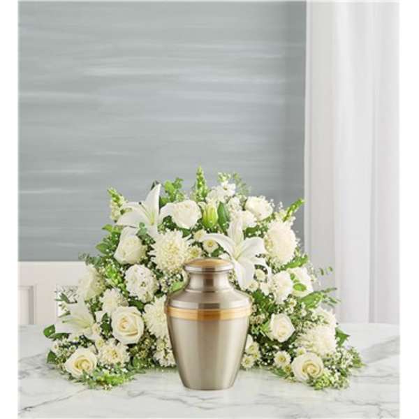 White floral funeral arrangement with an urn in front
