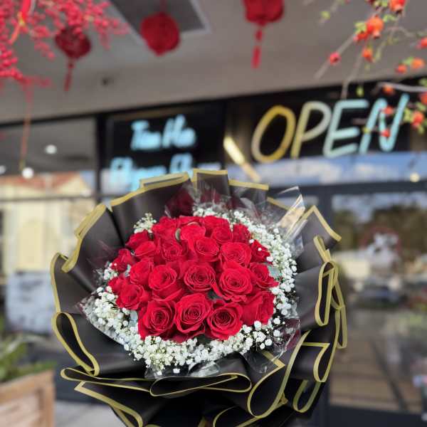 Bouquet of red roses with white baby's breath in black wrap