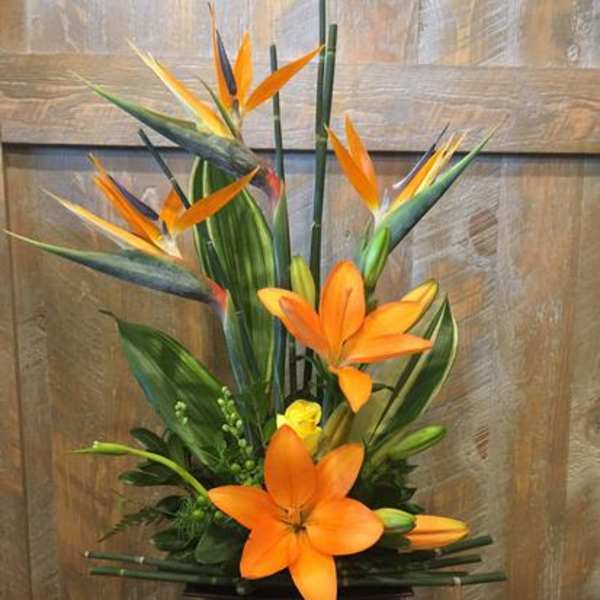 Tropical arrangement with orange lilies and bird of paradise flowers