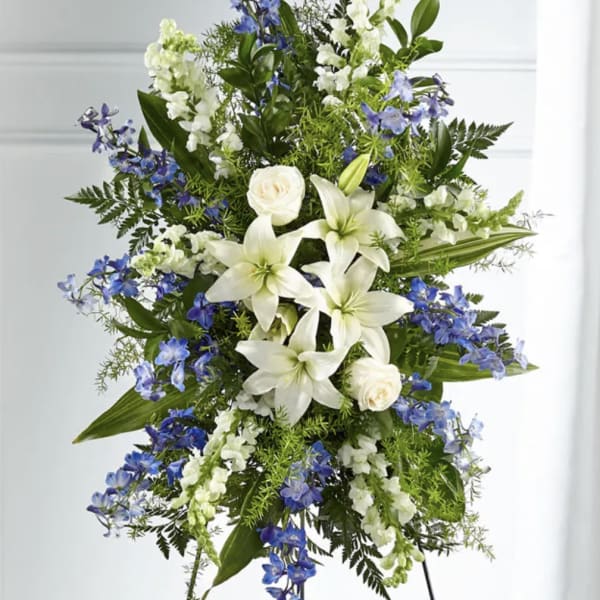 Tall standing floral spray with white lilies and blue flowers