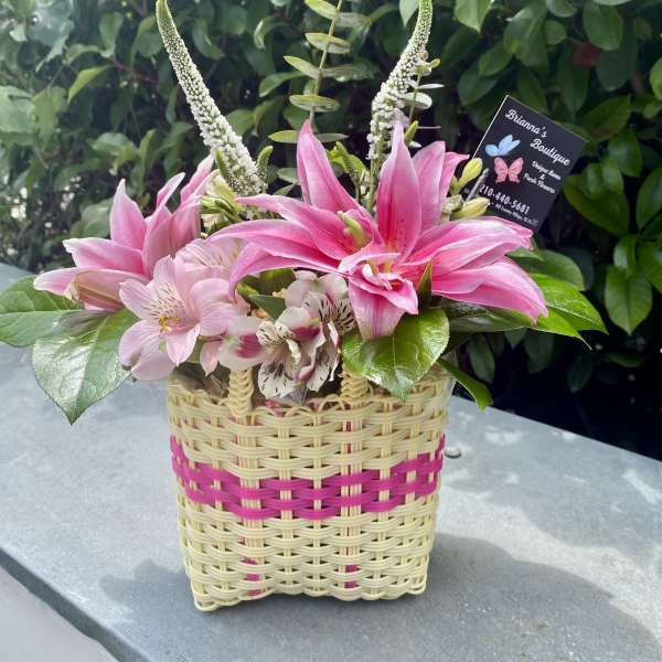 Pink lilies and alstroemeria in a woven basket