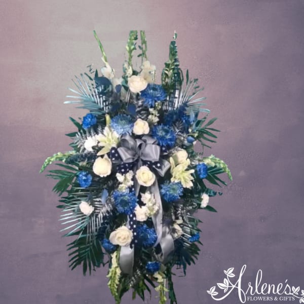 Blue and white floral standing spray with a silver ribbon bow